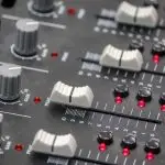 Buttons on a sound desk similar to one used by a sound engineer in a venue that could use Auracast
