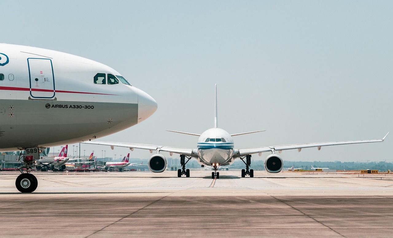 Two airplanes on a runway ready to take off at an unknown airport