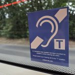 The EFHOH has launched a campaign called Hands Off Our Telecoils. A telecoil sign on a bus