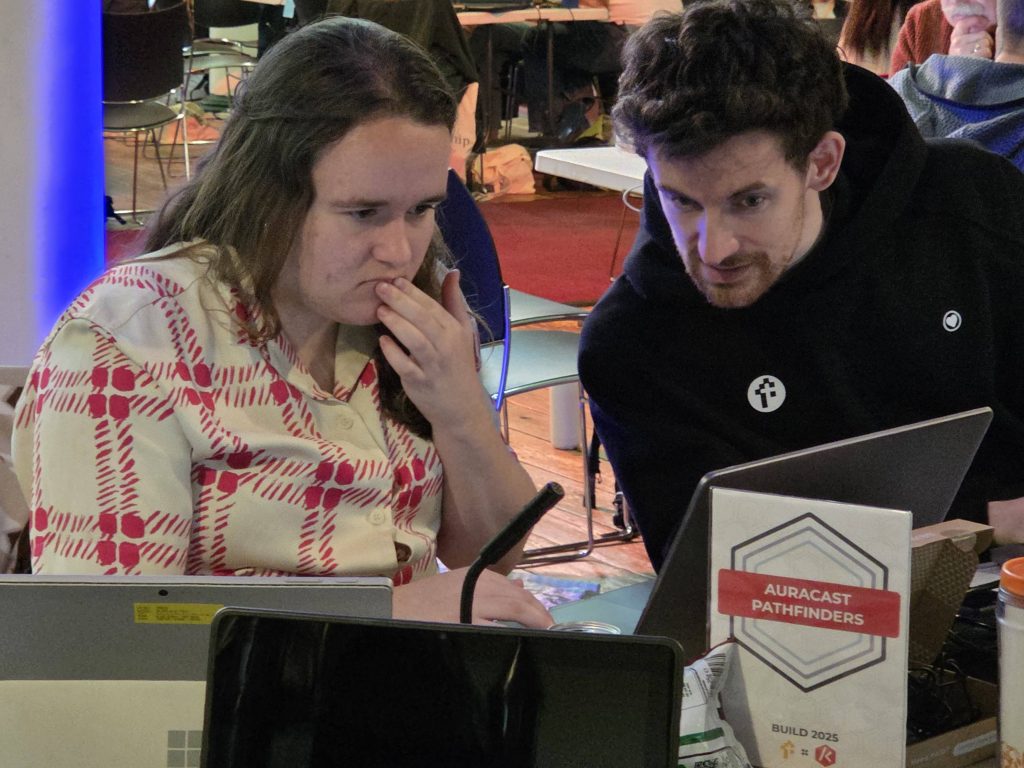 Two people working on the Auracast Pathfinders table at Kingdom Code