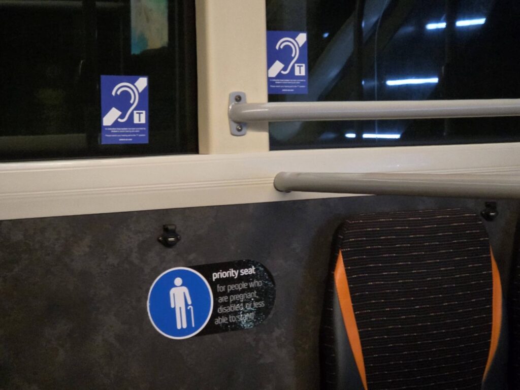 Telecoil logos stuck on windows of a Reading Bus
