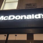 McDonald's sign lit up in the dark. The branches need Auracast