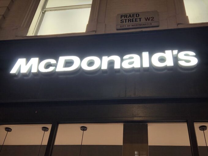 McDonald's sign lit up in the dark. The branches need Auracast