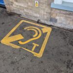 A telecoil symbol painted on a platform concourse