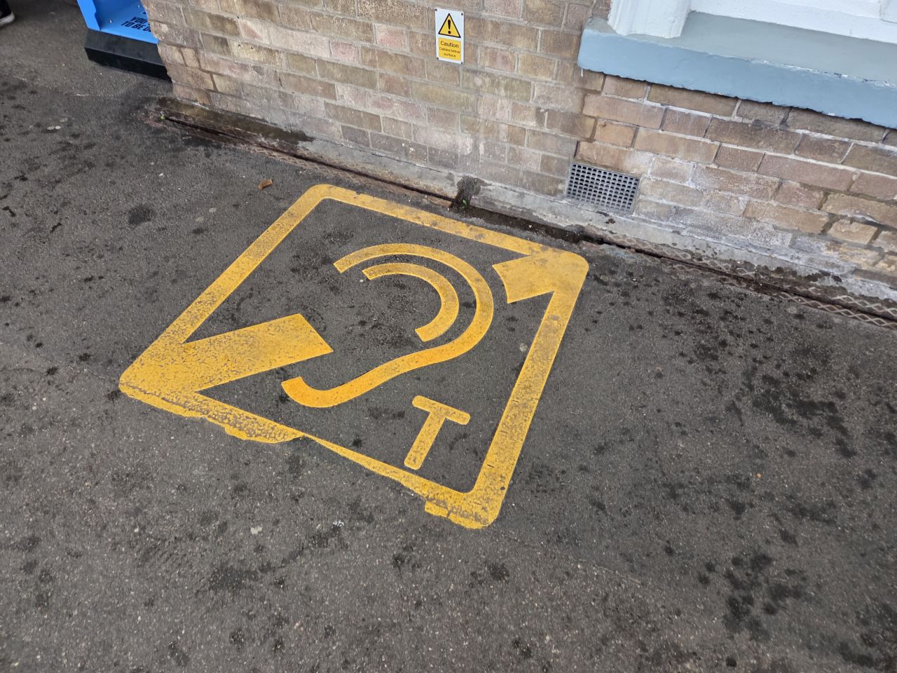 A telecoil symbol painted on a platform concourse