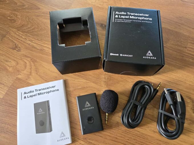 The Audeara Audio Transceiver and Lapel Microphone, cables and instructions taken from the box, which is above it