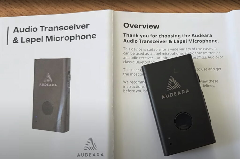 The Audeara Audio Transceiver and Lapel Microphone sitting on instructions for use