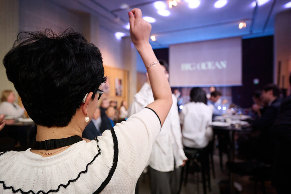 A hearing aid wearer dancing to Big Ocean with her arm in the air
