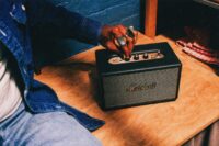 Marshall acton iv lifestyle 5. A man presses one of the control buttons