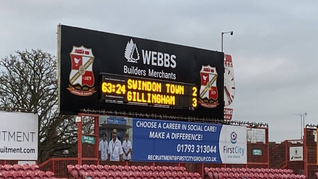 A scoreboard at Swindon FC showing Gillingham in the lead