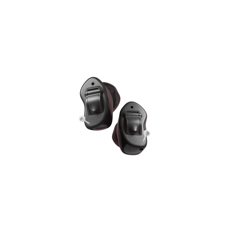 pair of dark grey and reddish-brown Completely-in-Canal (CIC) hearing aids with small removal pull strings, positioned against a white background. They appear to be in mid-air