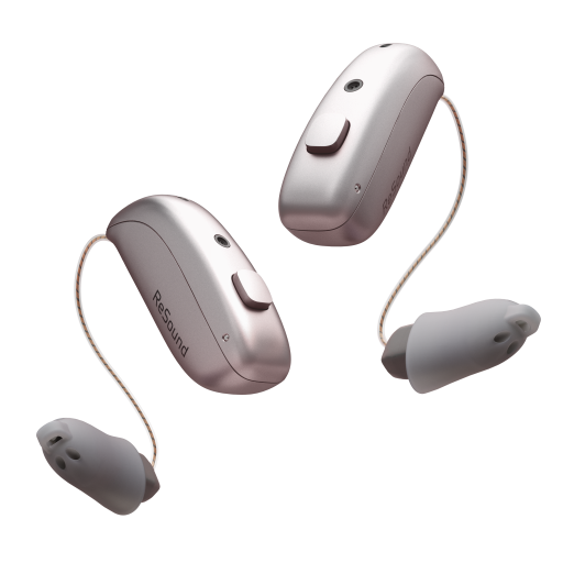 A pair of pinkish-gold ReSound Sensia hearing aids with "ReSound" printed on them, connected to thin wires and grey earpieces, floating against a white background
