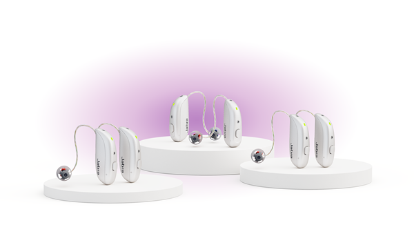 The Jabra Enhance Select M series of hearing aids with a pink glow behind them