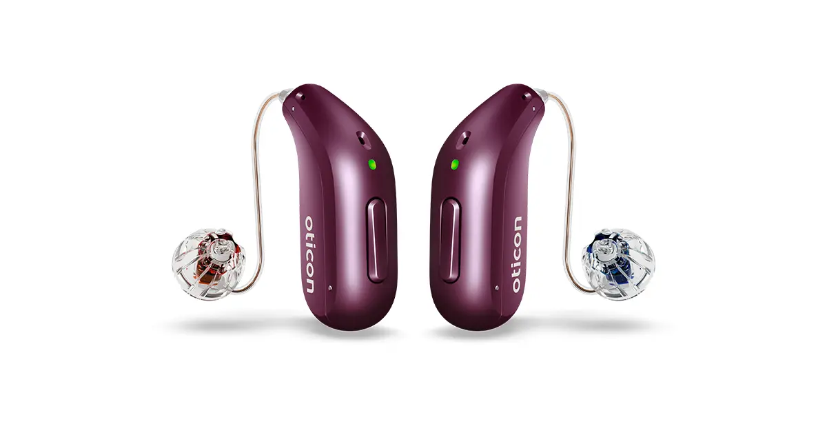 A pair of deep plum Oticon Reveal miniRITE hearing aids featuring clear domes and speaker wires against a white background.